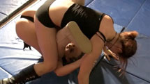 2 girls pinning each others on a wrestling mat